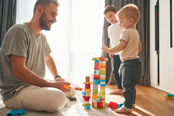 dad playing blocks with his little boys